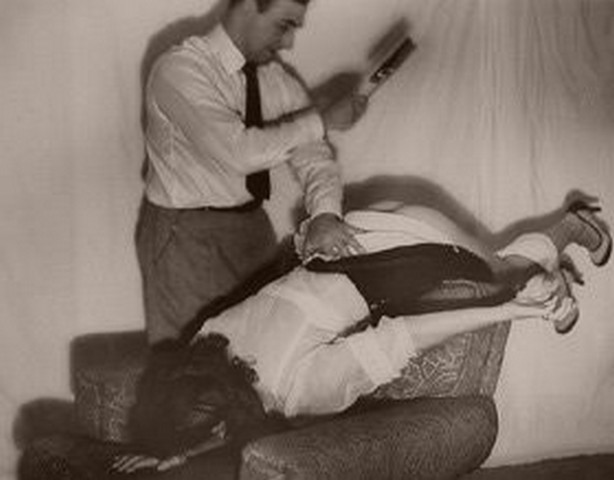 man giving woman 50's-style spanking rather ineptly