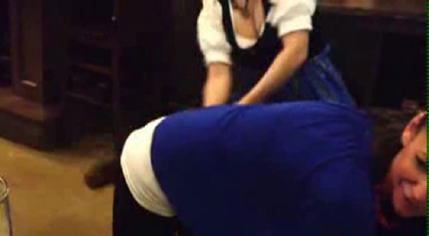 young woman gets paddled at the hofbrauhaus
